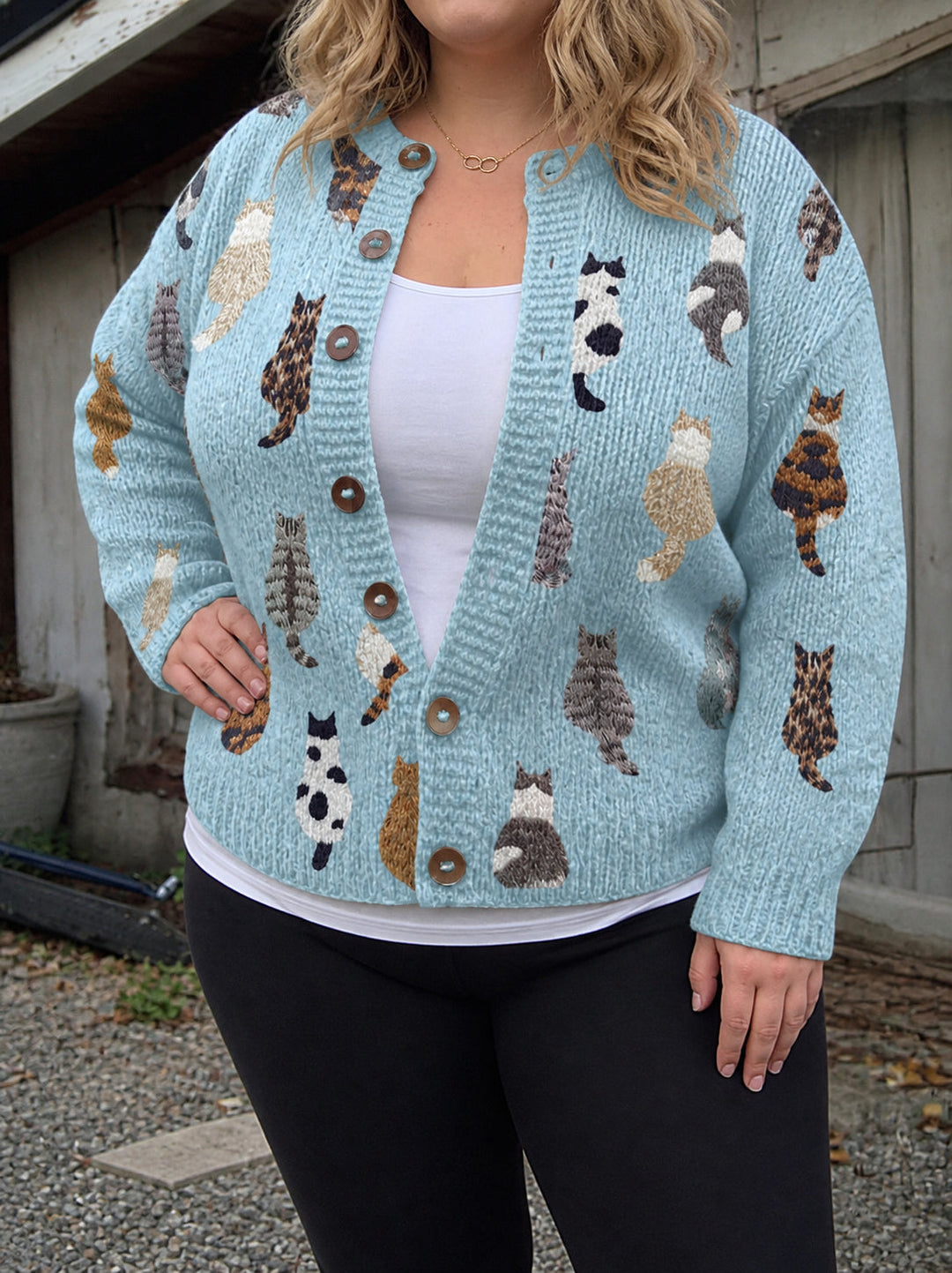 Dam i blå kattmönstrad kofta med knappar och svarta byxor