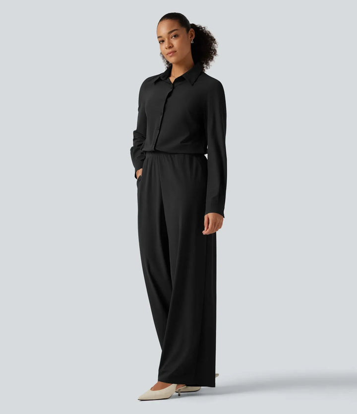 Sida av kvinna i långärmad svart jumpsuit med fickor