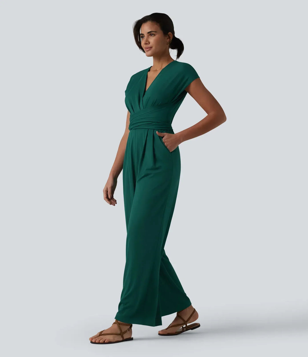Profilbild av kvinna i grön kortärmad arbetsjumpsuit med sidofickor synliga