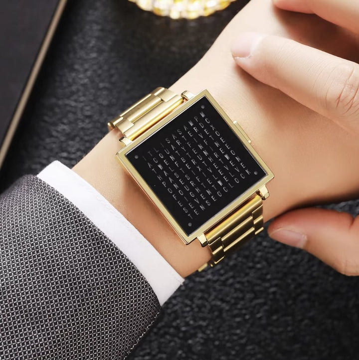 Elegant guld- och svart armbandsur med textvisning på handleden hos en person i kostym