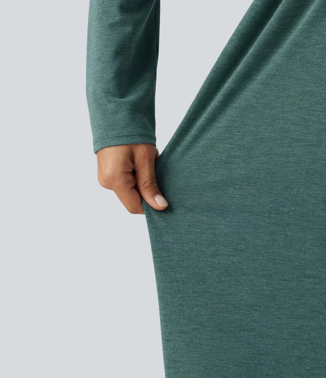 Närbild på tyget och sömmarna på den långärmade gröna jumpsuiten