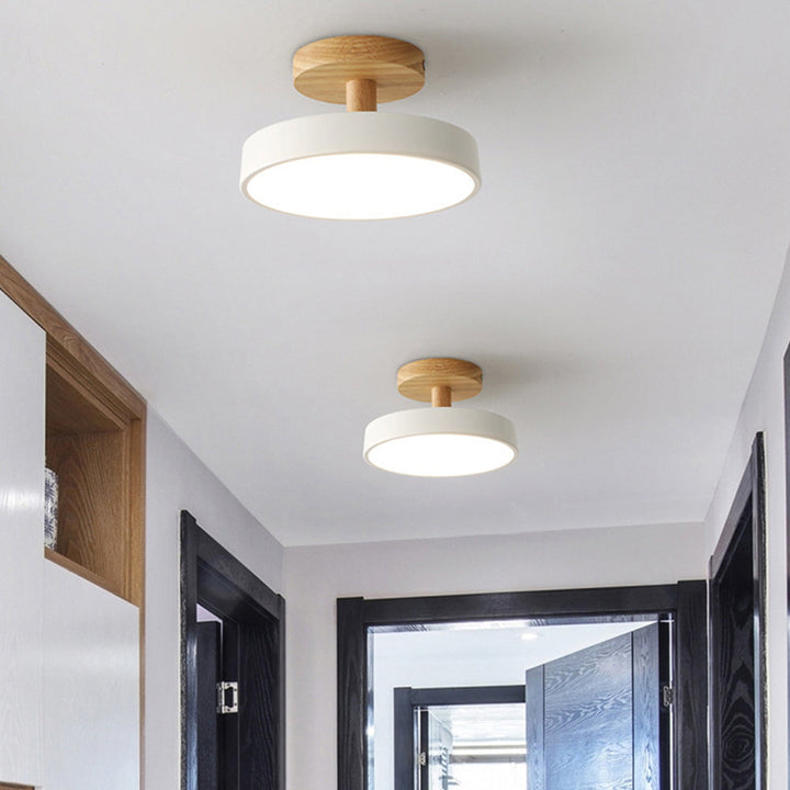 Vit modern LED taklampa i trä monterad i en hall