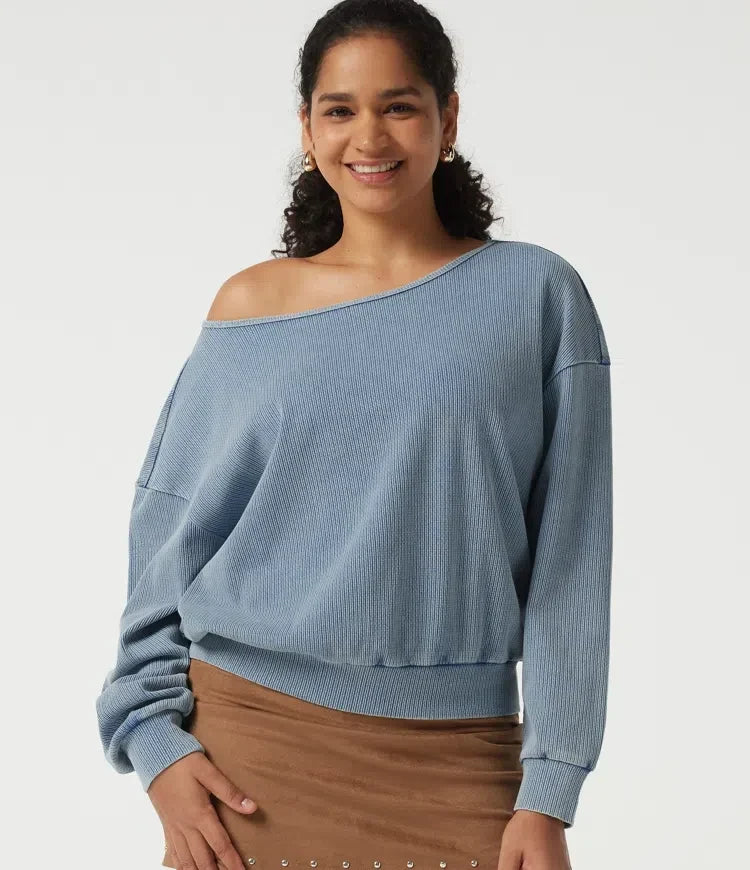 Kvinna som bär blå båtringad sweatshirt med fladdermusärm framifrån