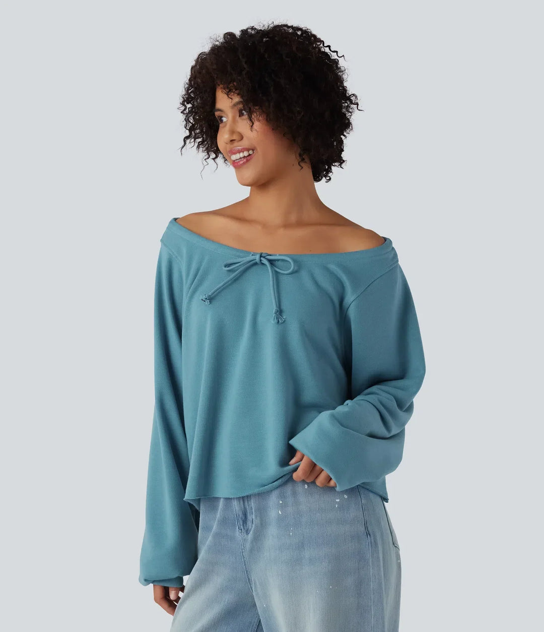 Sida av kvinna iklädd en blå vardaglig sweatshirt med dragsko