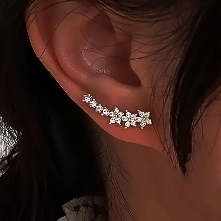 Elegant damaccessoar: blommiga örhängen i varm guldton