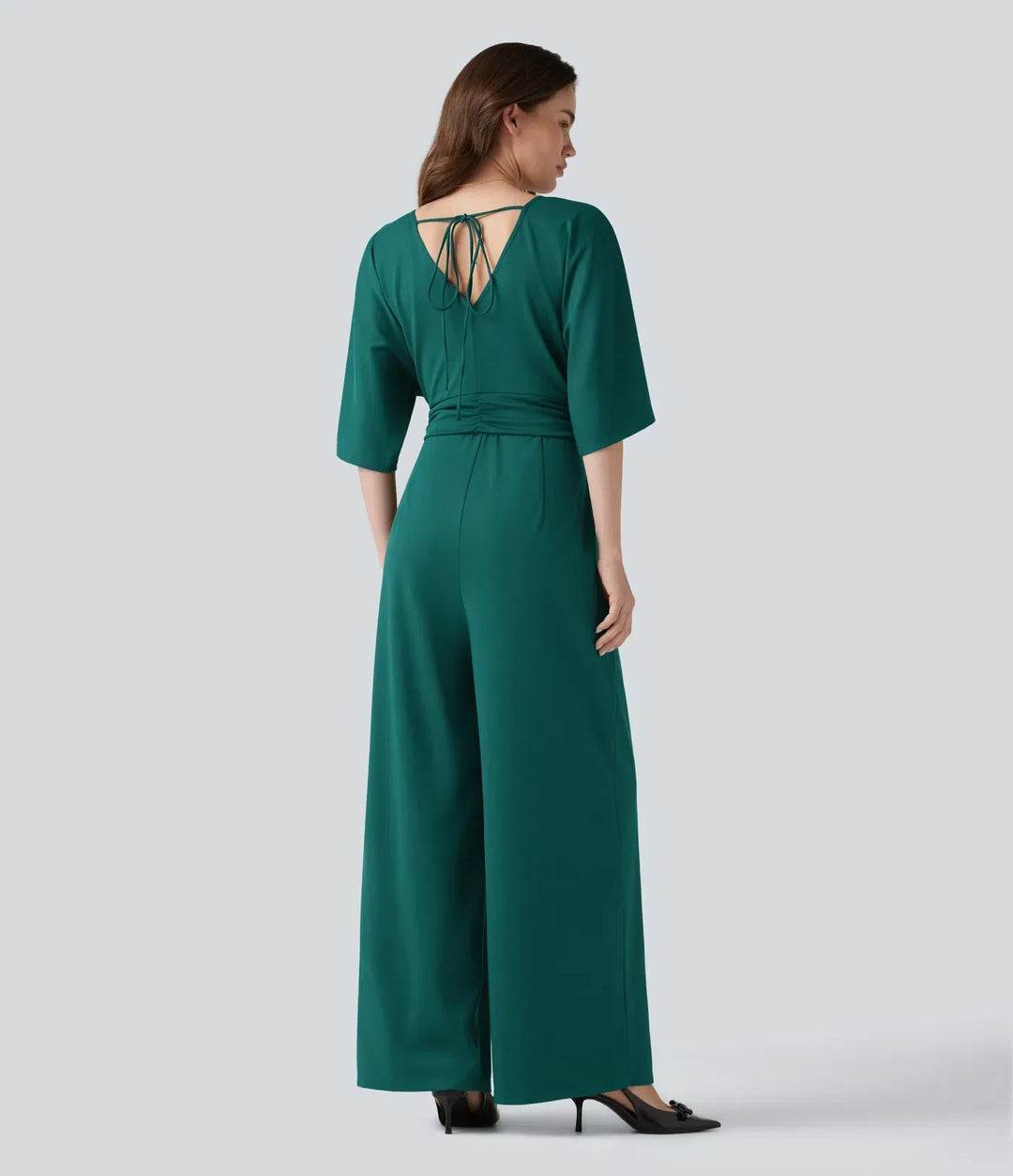 Baksida av grön damjumpsuit med knytdetalj i ryggen