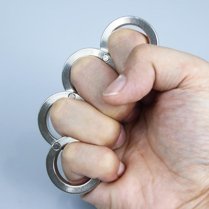 Vikbar fyrfingerutlösarring hållen i handen för stresslindring