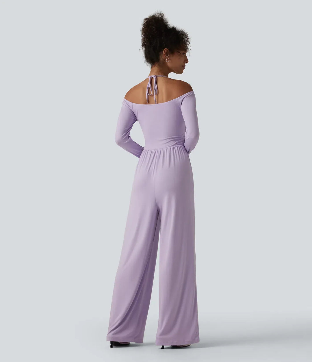 Baksida av lila ribbad jumpsuit med knytning i nacken och bara axlar