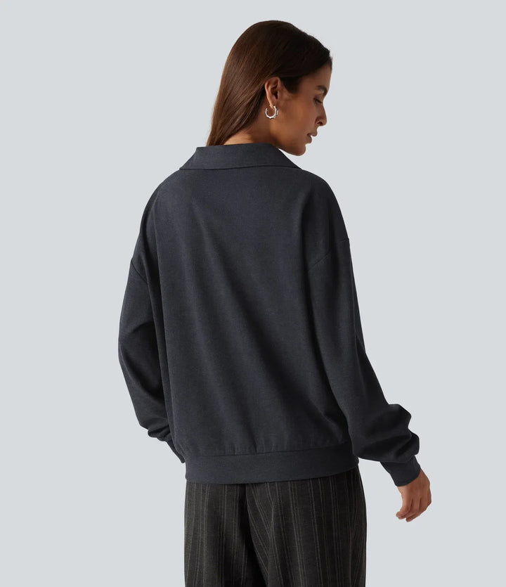 Kvinna i mörkgrå sweatshirt bakifrån med nedhasade axlar