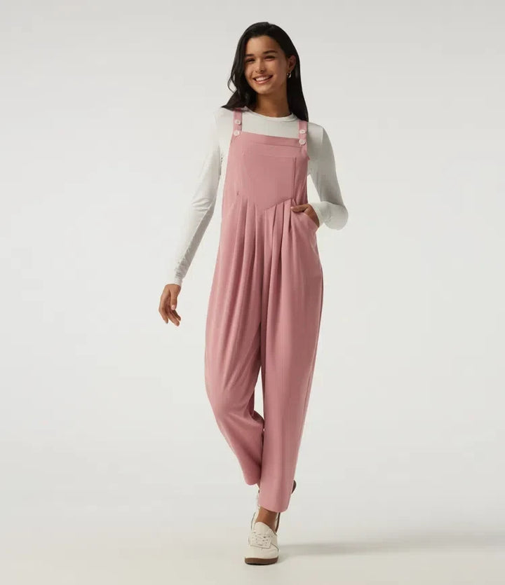 Modell som bär rosa ärmlös overall med fyrkantig halsringning framifrån