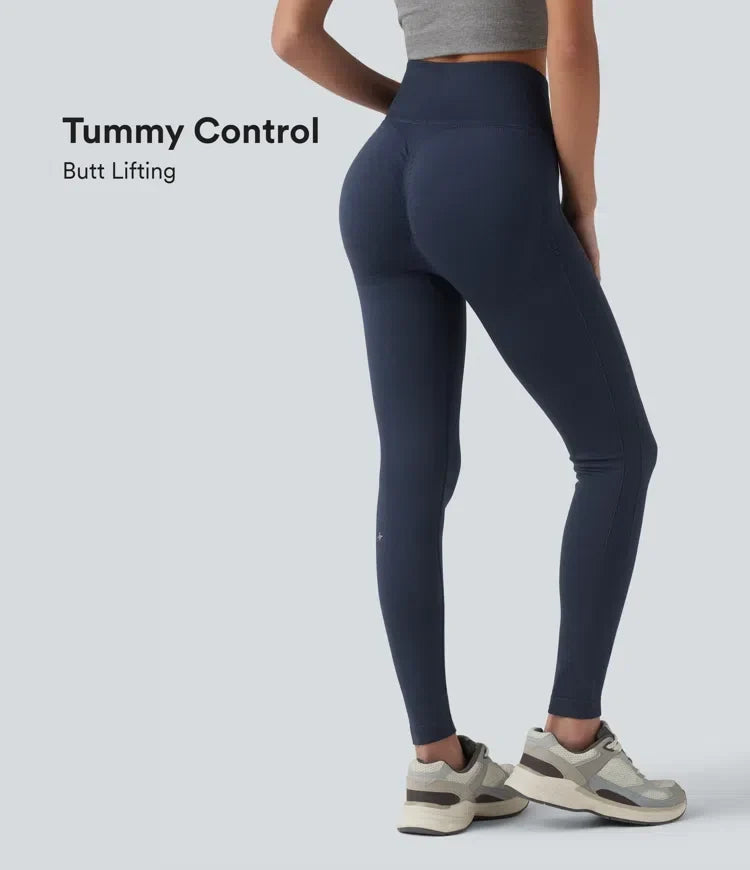 Kvinna som visar baksidan av mörka yogaleggings med rumplyftande effekt