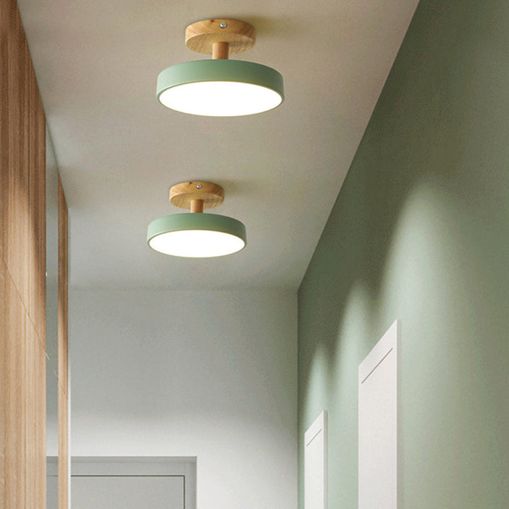 Svart industriell lampa med trädetaljer monterad i stilren hall