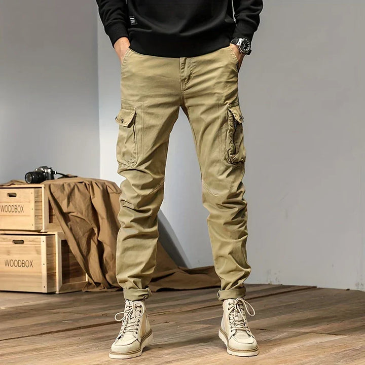 Man i khakifärgade cargo joggers med rymliga sidfickor och kängor