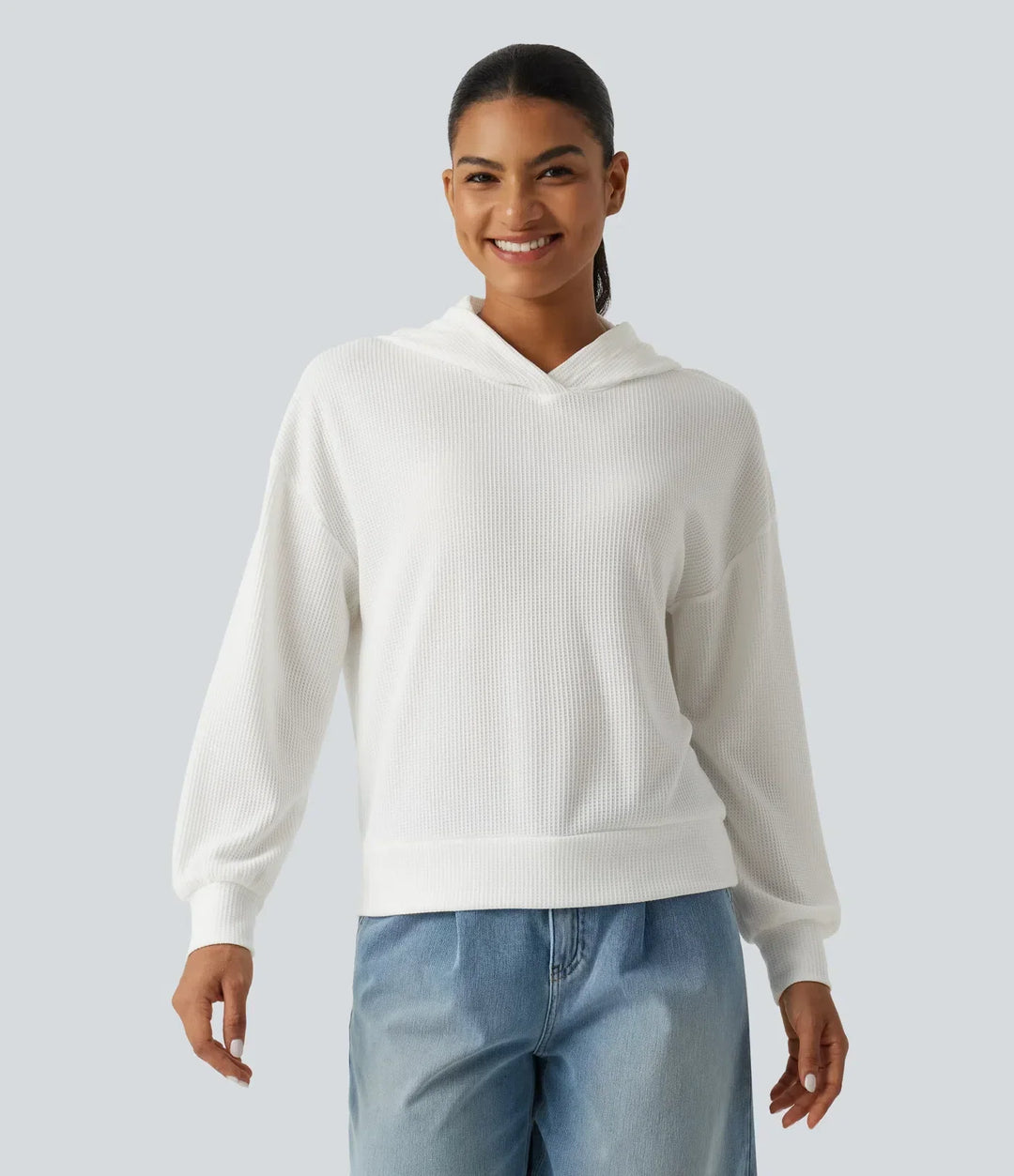 Helbild på dam i modern sweatshirt med huva och våffelstruktur