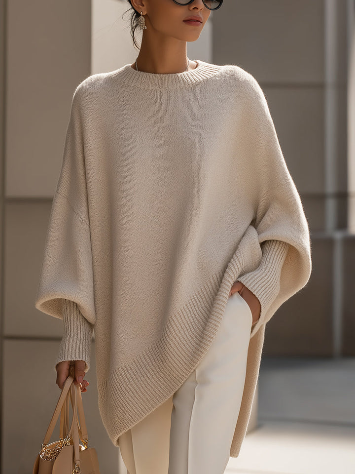 Kvinna i elegant beige stickad tröja med vida ärmar utomhus