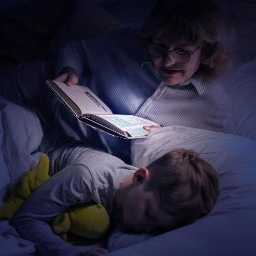 Person som läser bok i sängen med skonsam panellampa