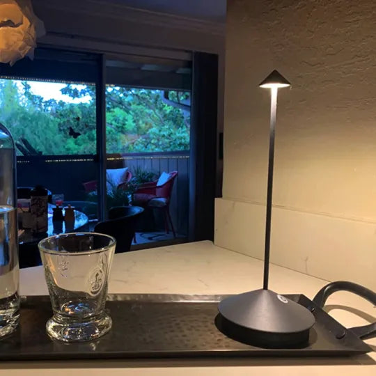 Vit trådlös LED-lampa som står fint på en hylla omgiven av gröna växter
