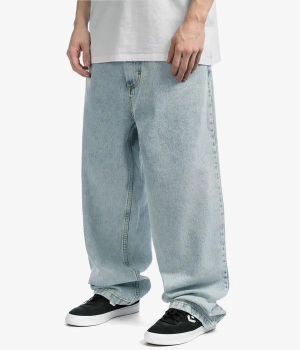 Modell i ljusblå baggy jeans och vit t-shirt