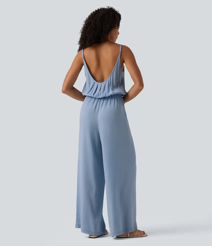Kvinna i ljusblå slip jumpsuit bakifrån med tunna axelband