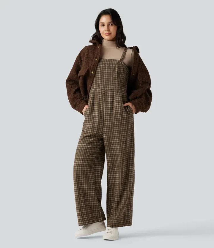 Kvinna som bär en rutig jumpsuit med fickor tillsammans med en brun fluffig jacka och vita sneakers