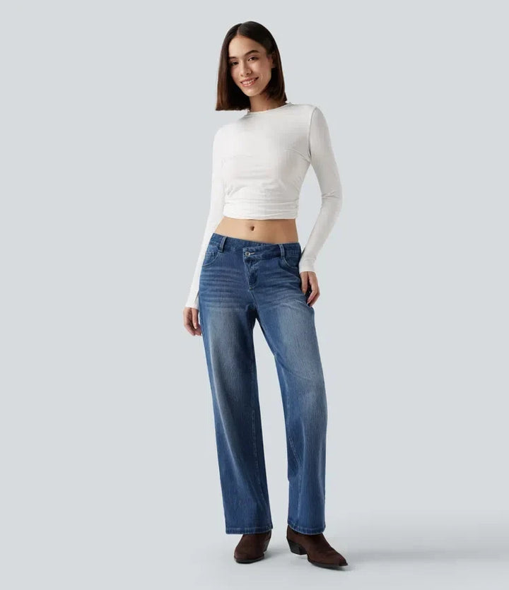 Närbild på knapp och gylf på damjeans med låg midja