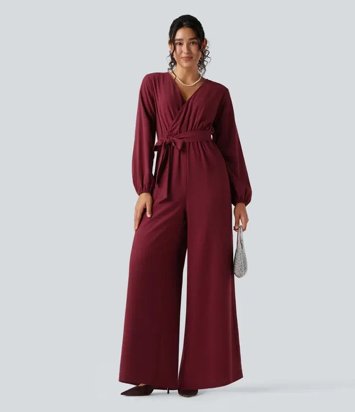 Modell i vinröd långärmad jumpsuit med vida ben framifrån