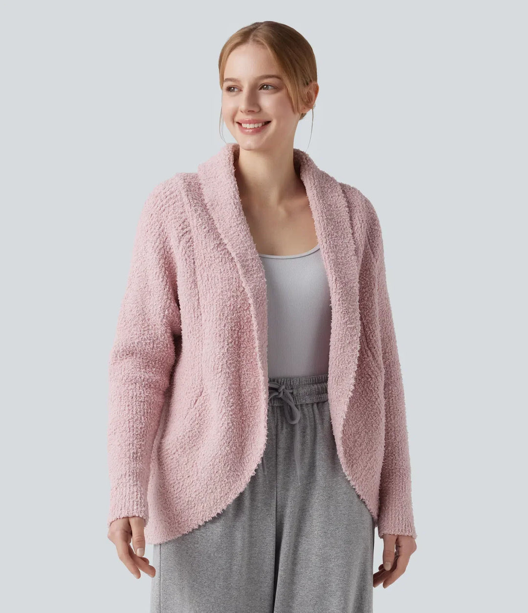 Närbild på kvinna iklädd elegant vardagscardigan i ljusrosa färg