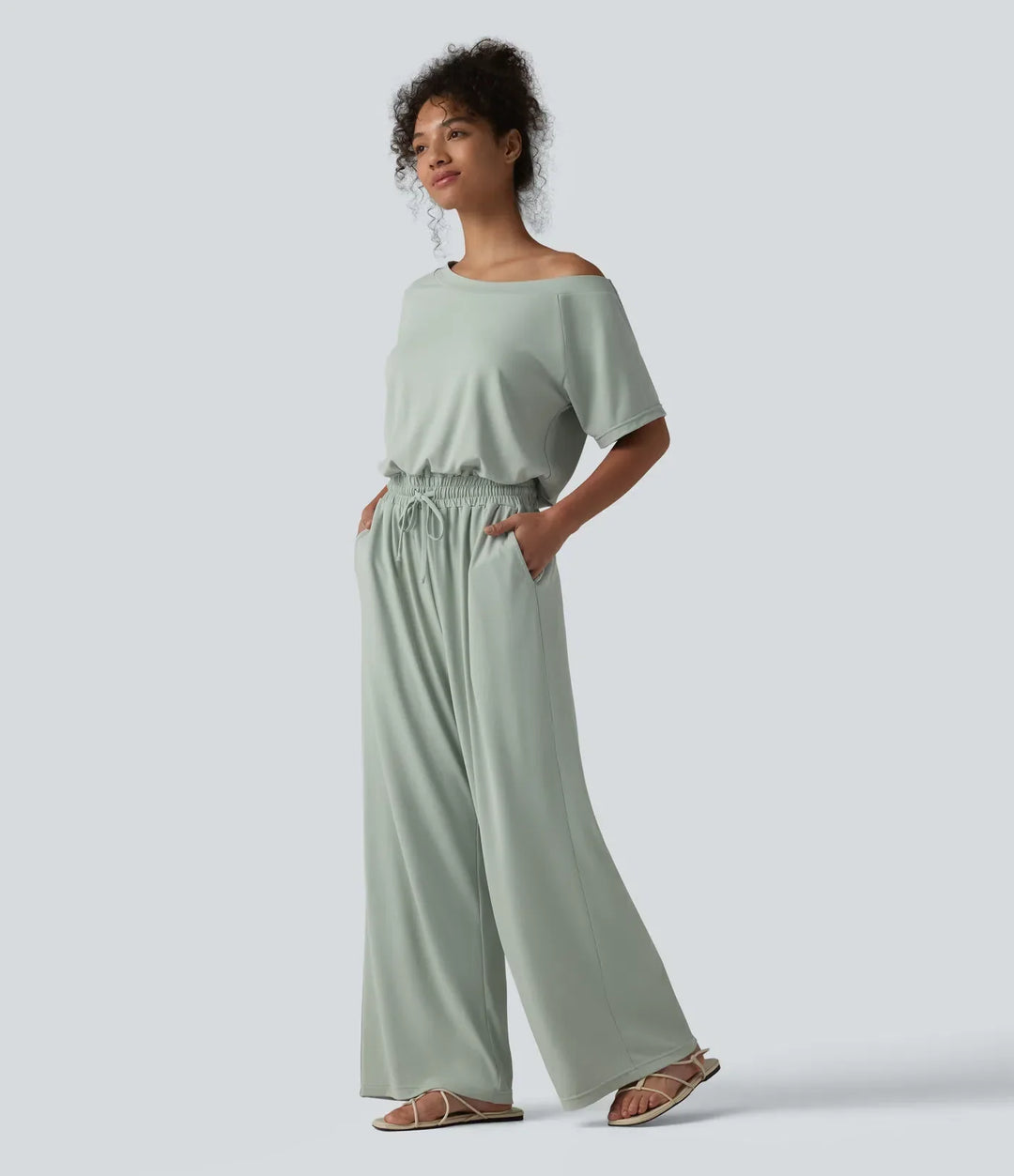 Sida av kvinna i bekväm vardaglig jumpsuit med elastisk midja