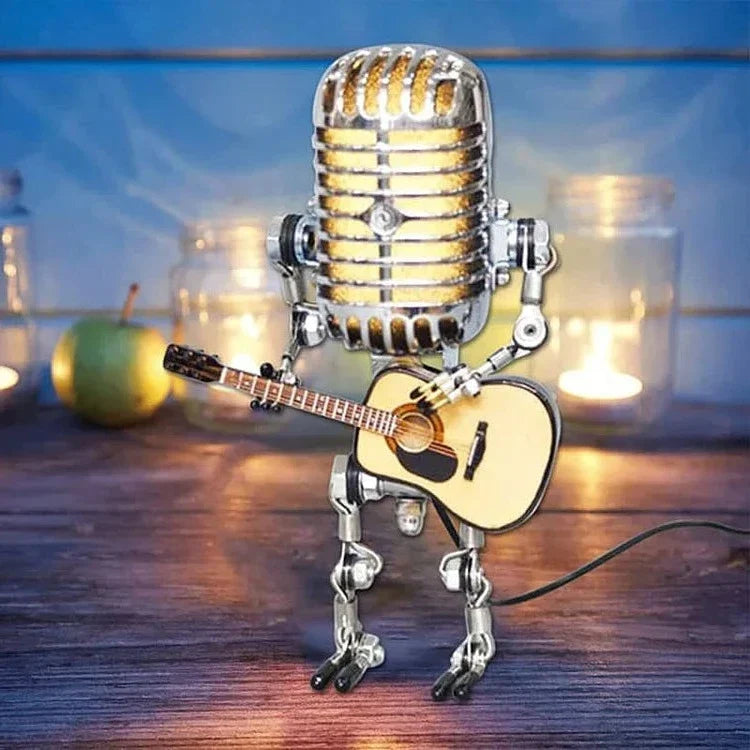 Vintage metallmikrofon robot med klassisk gitarr stående på träbord