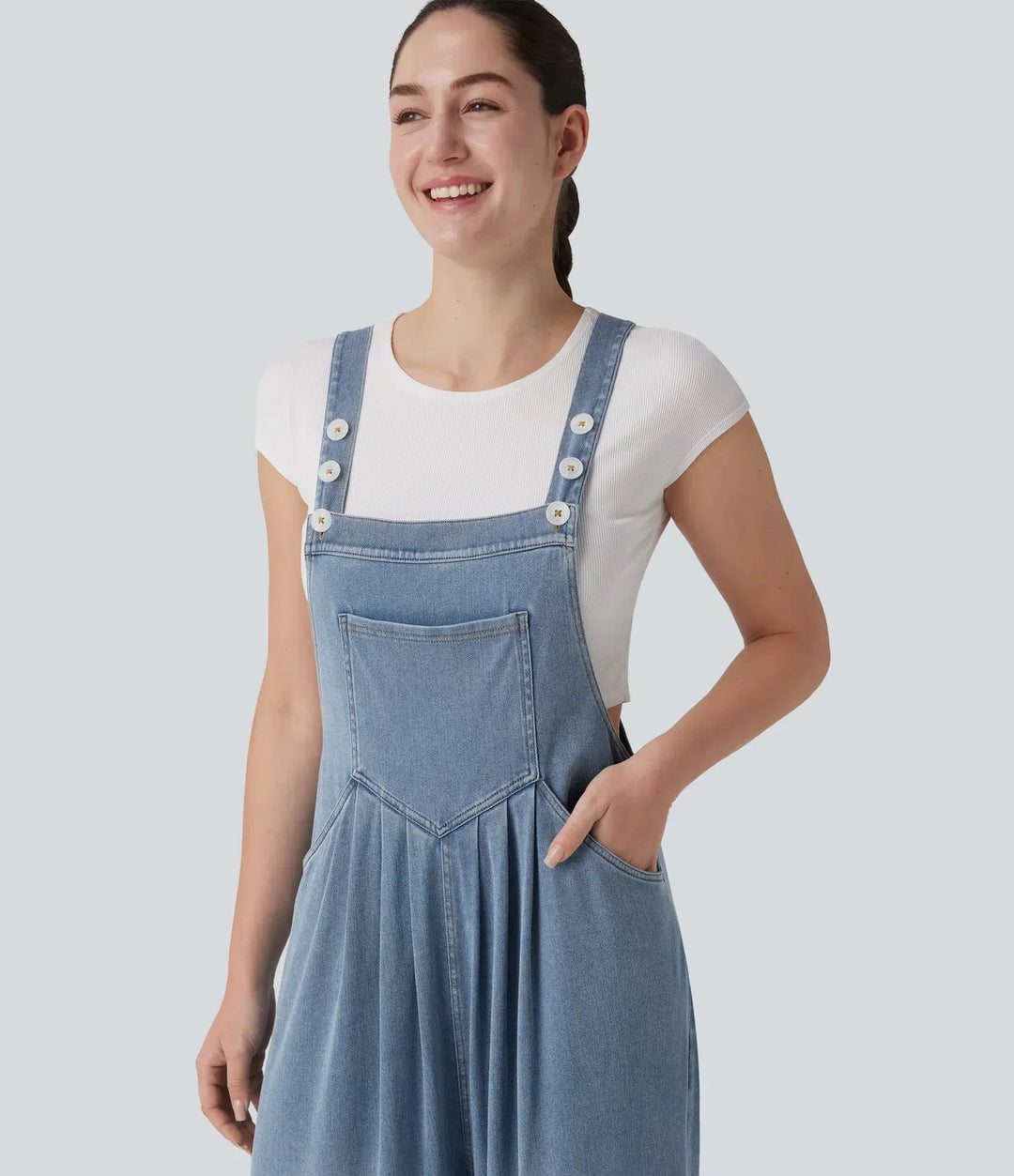 Casual draperad damoverall med praktiska fickor och justerbara axelband bakifrån