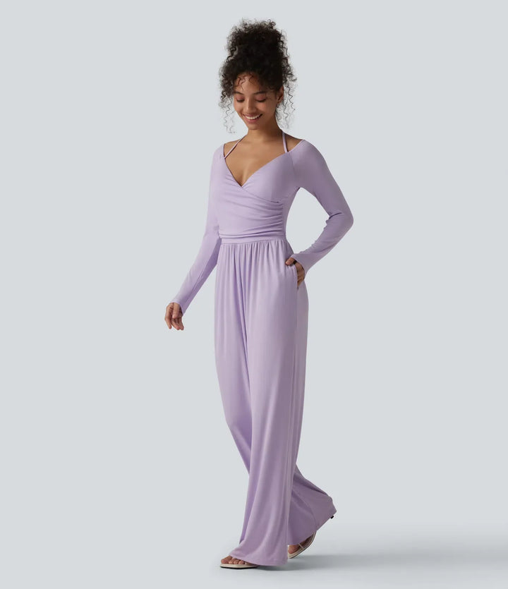 Helbild framifrån på modell i lila långärmad jumpsuit med fickor