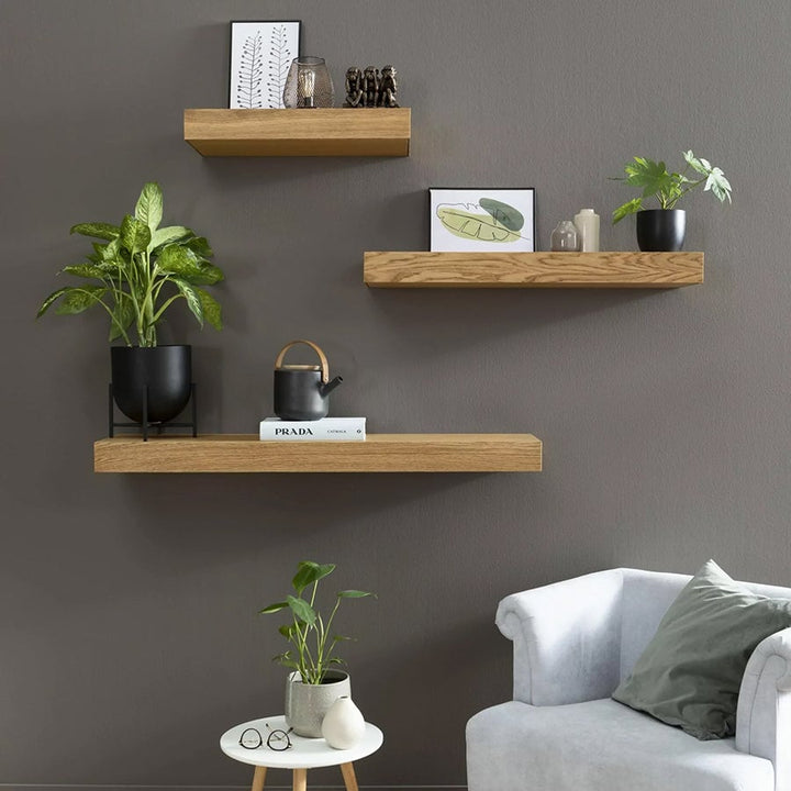 Närbild på vit flytande vägghylla med minimalistisk design och integrerat förvaringsfack