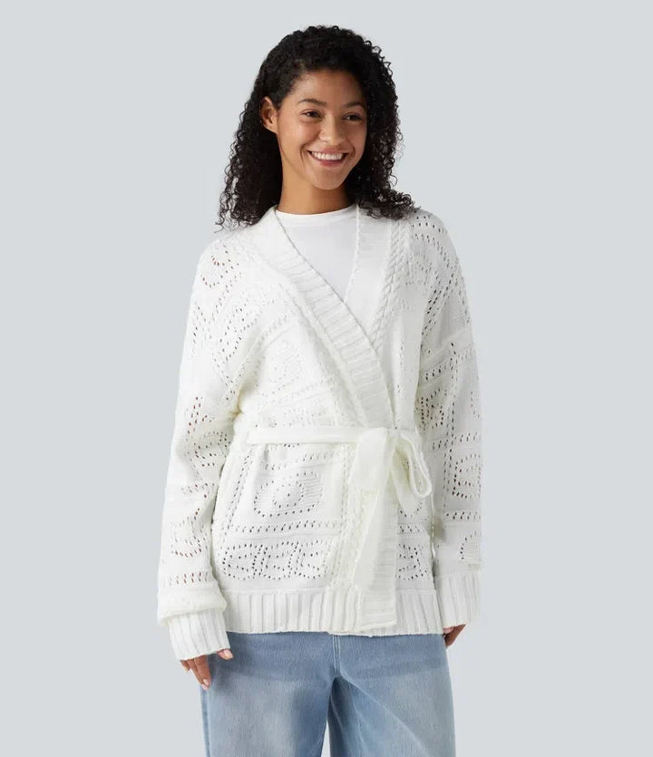 Kvinna som bär vit stickad cardigan med bälte framifrån