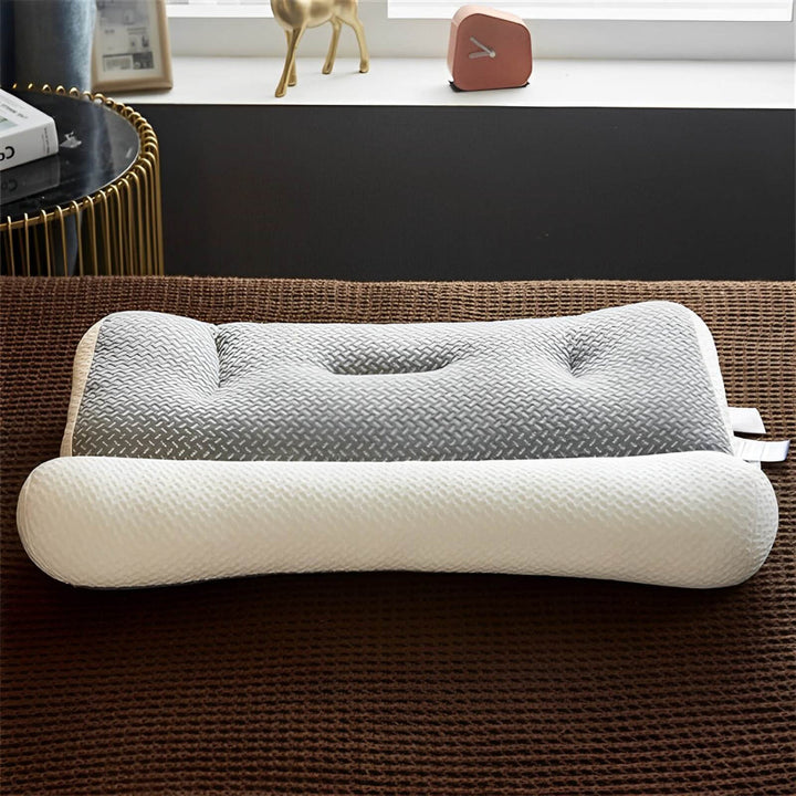 Snygg grå sovkudde med ergonomisk design liggande på sängen