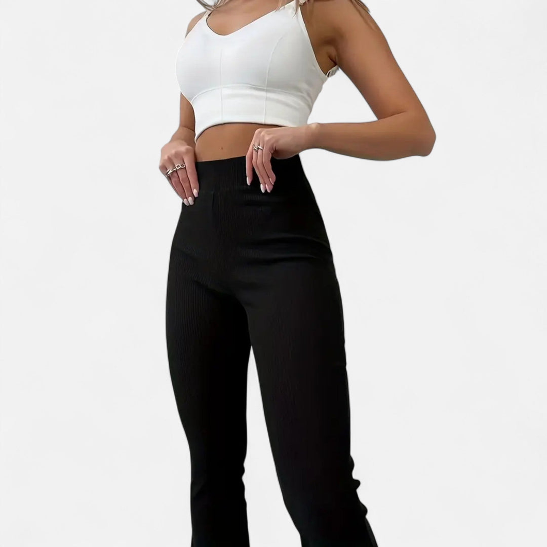 Kvinna i svart crop top och högmidjade ribbade leggings framifrån