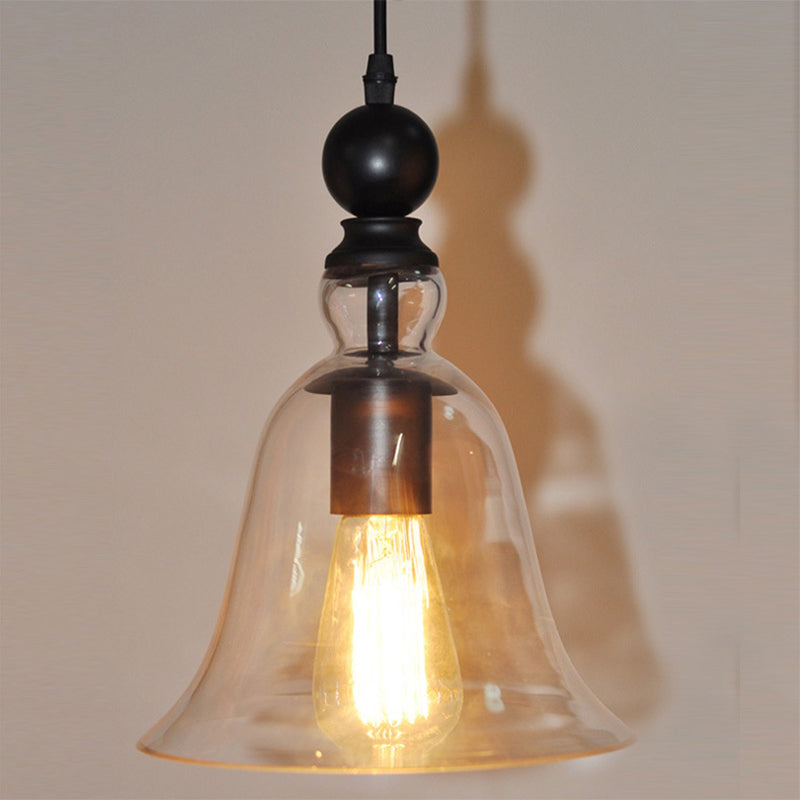 Närbild på hängande belysningsarmatur med tänd glödlampa