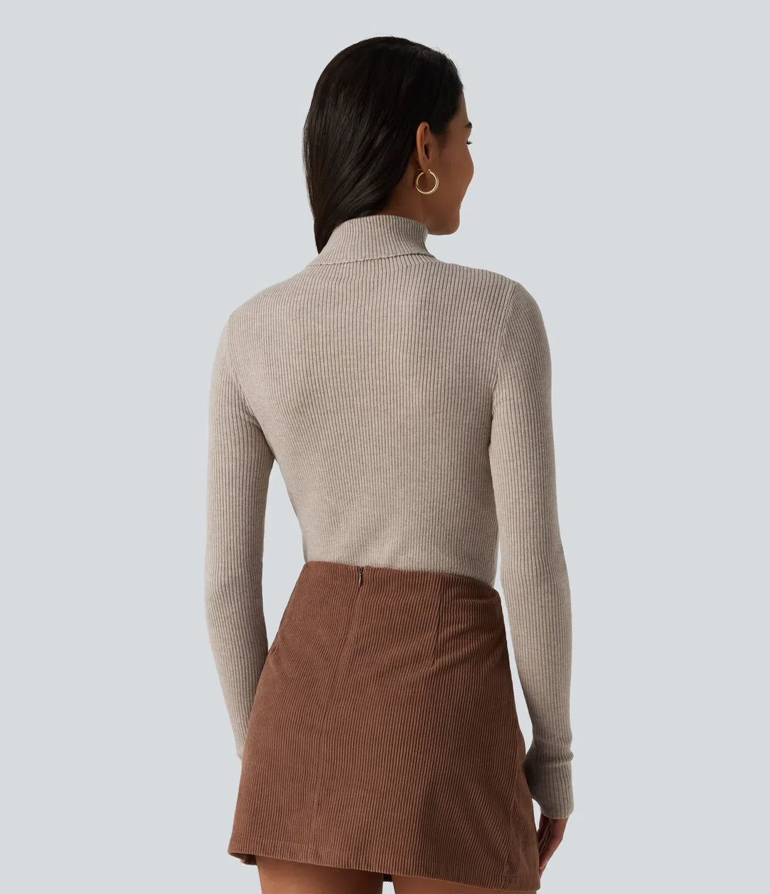 Kvinna i beige långärmad tröja bakifrån