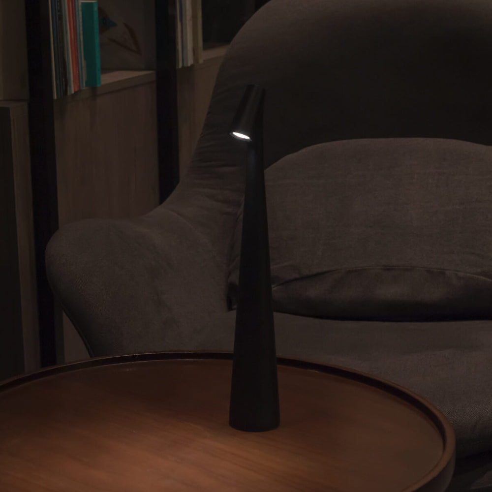 Atmosfäriskt ljus från en trådlös designlampa på nattduksbordet