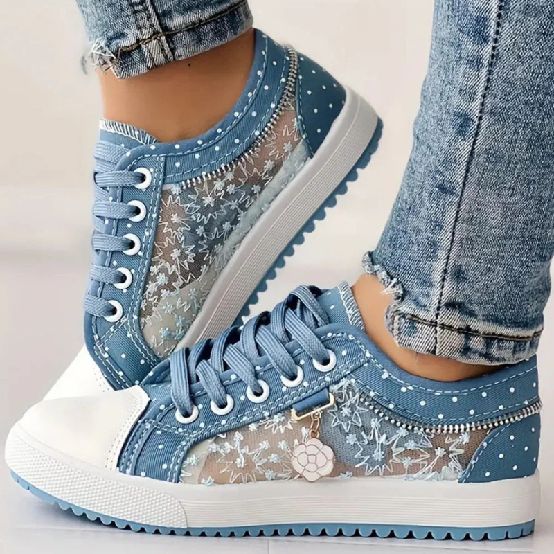 Närbild på dam sneakers i ljusblått med spetsdetaljer och vita snören