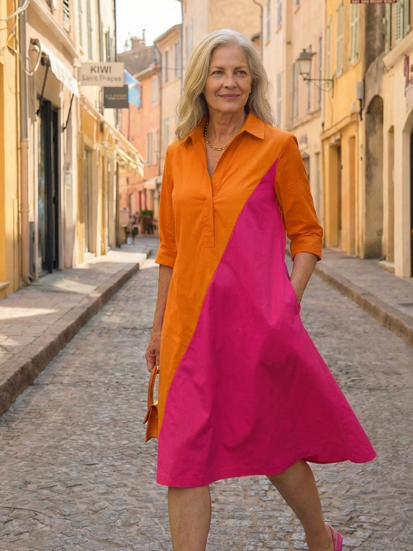 Kvinna i orange och rosa vardagsklänning utomhus på gata