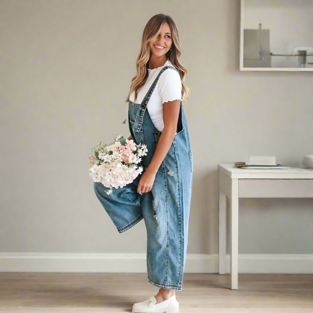 Kvinna som bär ljusblå vintage jumpsuit med vita loafers och blommor