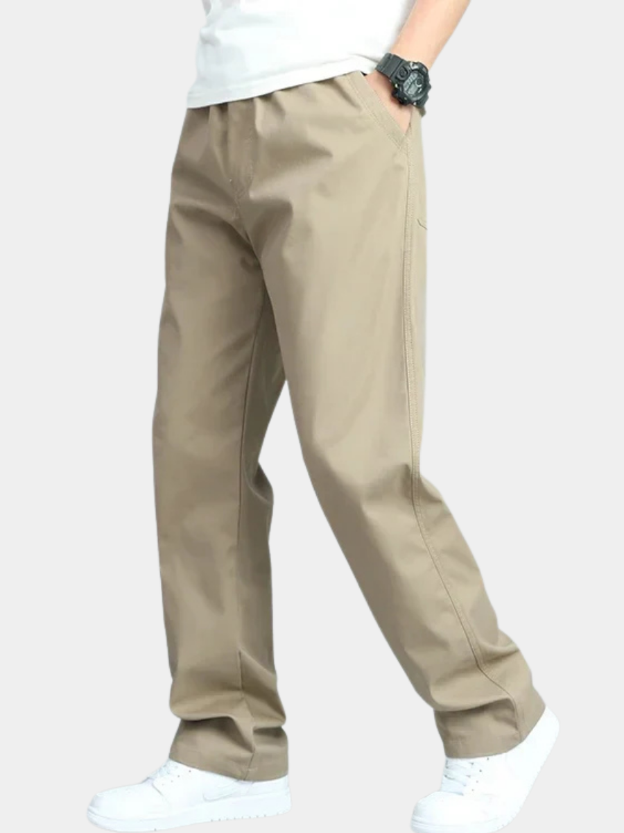 Man i profil som bär vida bomullsbyxor i khaki med vit t-shirt