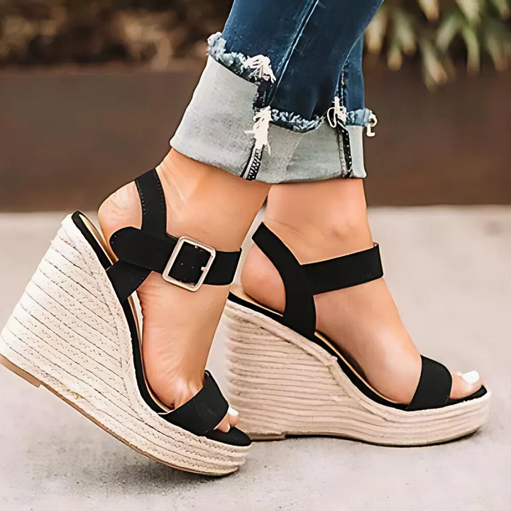 Svart damandal med kilklack och spänne buren med uppvikta jeans