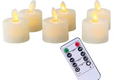 Sex vita flamsäkra ljus tillsammans med en trådlös fjärrkontroll mot vit bakgrund