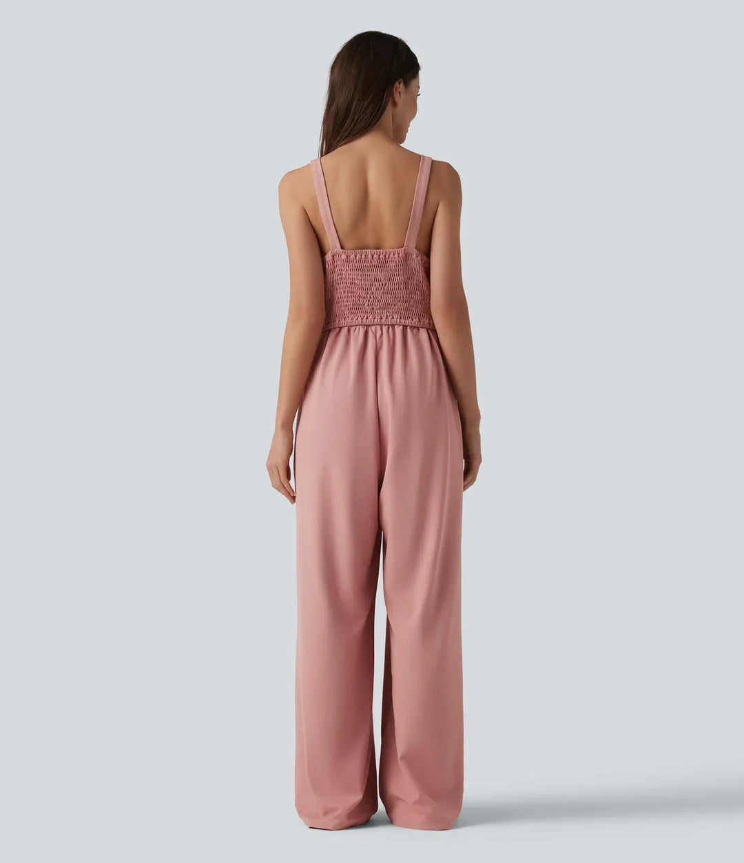 Baksida av rosa ärmlös jumpsuit med smockad detalj