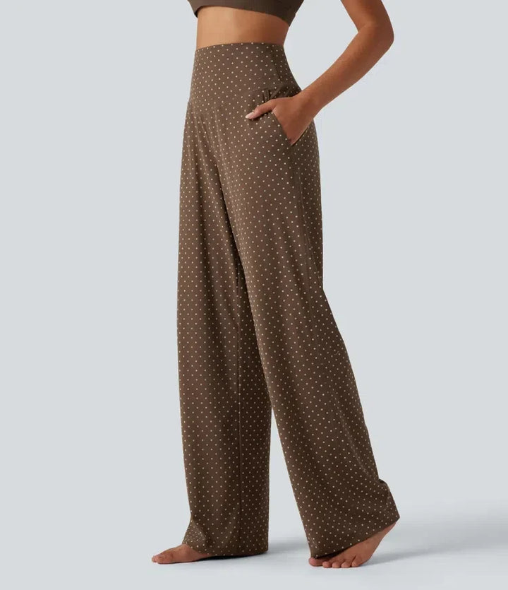 Sida av brun högmidjad prickig yogabyxa med synlig ficka