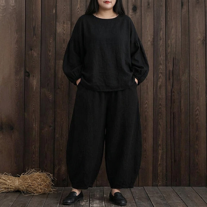 Svart plus size modell som visar lanternbyxornas vackra fall och passform