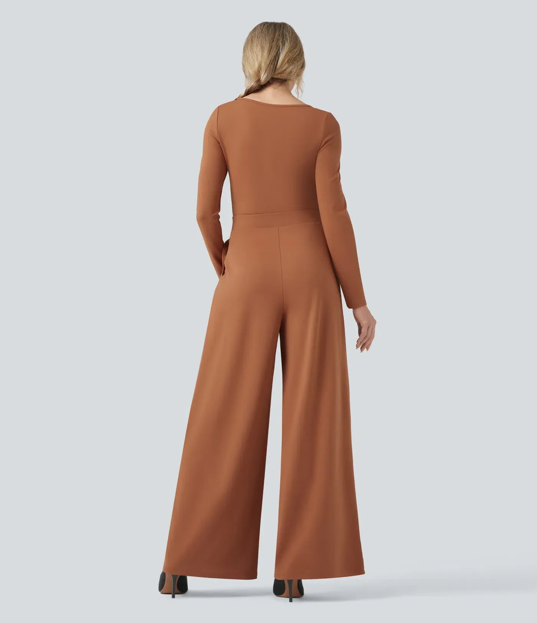 Baksida av brun långärmad jumpsuit med vida ben