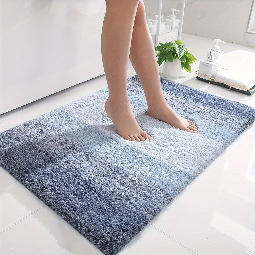Blå mjuk mikrofiber badmatta som ligger på ett ljust klinkergolv i ett badrum