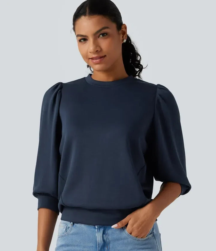 Framifrån av dam i mörkblå sweatshirt med puffärm